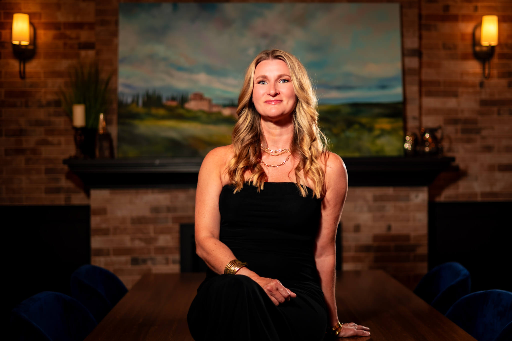 Callie Croken, a life and business coach, confidently sitting in a black strapless dress during her branding photoshoot with Lake Design.