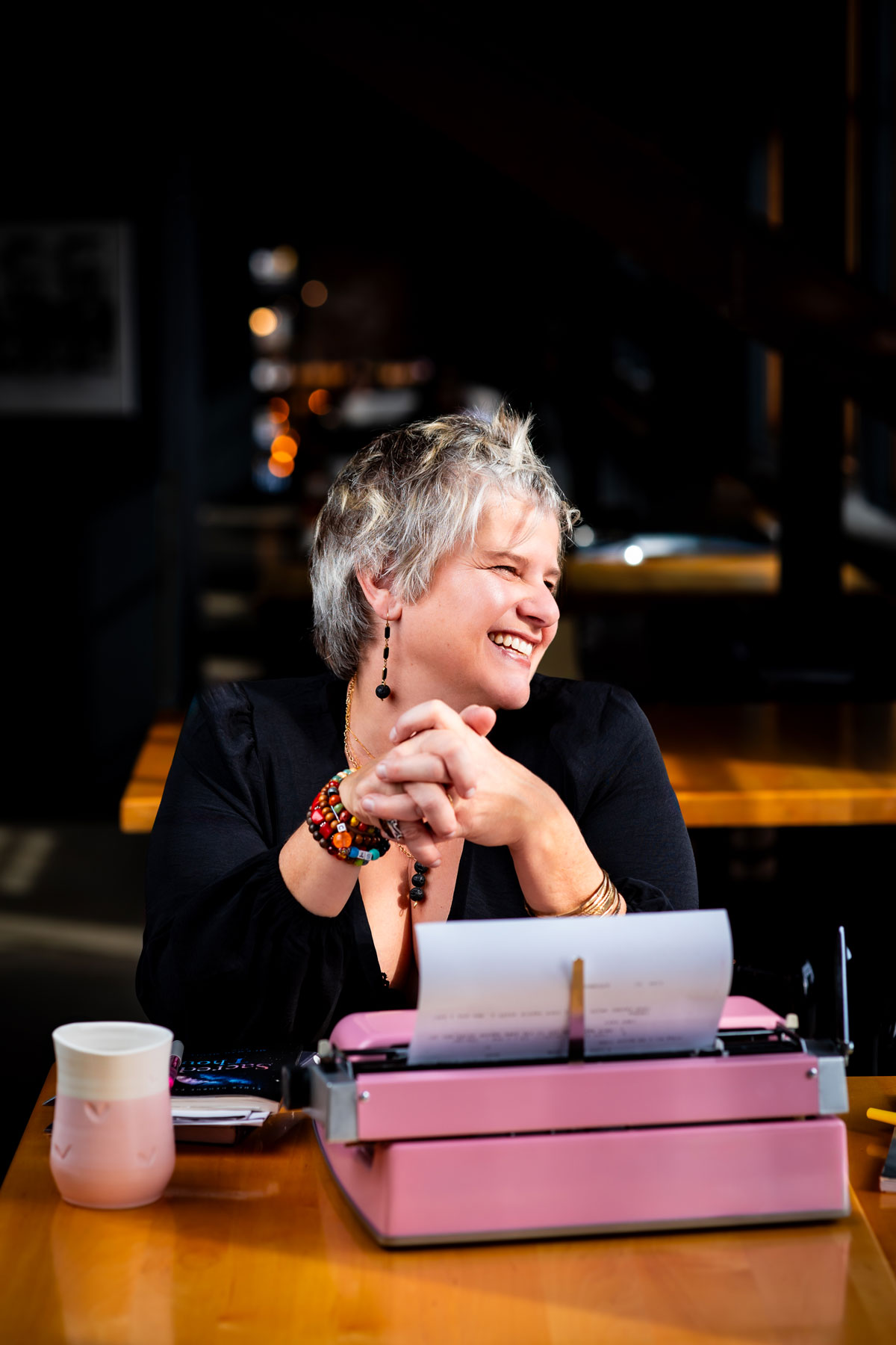Callie Croken, a life and business coach, sipping coffee playfully in a window sill during her branding photoshoot with Lake Design.